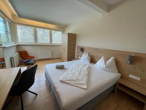 a hotel room with a bed and a table and chairs at Hotel Grazerhof in Bad Gleichenberg