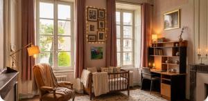 a living room with a crib and a desk and windows at La Miséricorde-Deluxe room with kids room in Coutances
