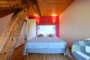 a bed in a room with a red wall at Le mouly/petit gite in Miossens-Lanusse +28 photos