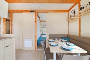 a small kitchen and dining room with a table and chairs at Camping 3 étoiles - ccbfggd in Lepin-le-Lac