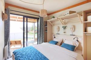 a bedroom with a large bed with blue pillows at Camping 3 étoiles - ccbfggd in Lepin-le-Lac