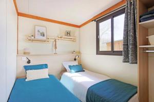 two beds in a small room with a window at Camping 3 étoiles - ccbfggd in Lepin-le-Lac