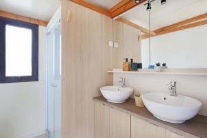 a bathroom with two sinks and a mirror at Camping 3 étoiles - ccbfggd in Lepin-le-Lac +13 photos