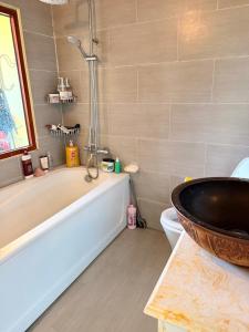 a bathroom with a tub and a sink at Líu homestay in Klong A