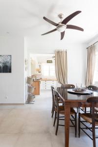 a dining room with a ceiling fan and a table at Eagle House Spetses 4 bedrooms in Spetses