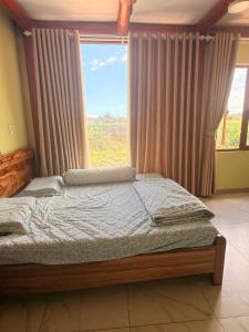 a bedroom with a bed and a large window at Líu homestay in Klong A