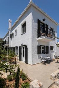 a white house with a patio in front of it at Eagle House Spetses 4 bedrooms in Spetses