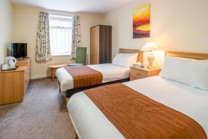 a hotel room with two beds and a television at Carrington House Hotel in Bournemouth +24 photos