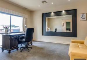 an office with a desk and a mirror on the wall at Home in Highton in Highton