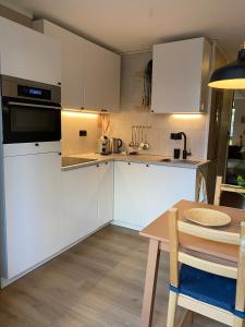 a kitchen with white cabinets and a wooden table at Appartement met jacuzzi in Huizen in Huizen