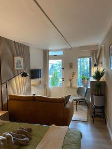 a living room with a couch and a living room with a table at Appartement met jacuzzi in Huizen in Huizen