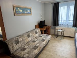 a living room with a couch and a table at Hotel Mykonos in Eschweiler