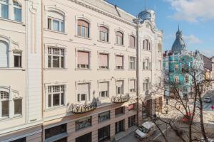 a large white building with balconies on a city street at Casa Doseanu , Stern Palace Historic Residence in Oradea