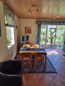 a living room with a table and chairs and a tv at Ferienhof Michaelis in Bruchhausen-Vilsen