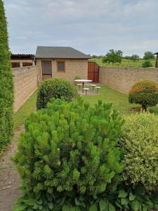 a garden with a picnic table and a brick wall at Vinný sklep Tesařík in Prušánky