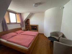 a small bedroom with a bed and a chair at Vinný sklep Tesařík in Prušánky