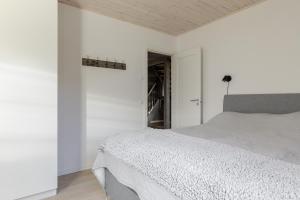 a white bedroom with a bed and a wooden ceiling at Röningen 24 - Bruksvallarna in Bruksvallarna