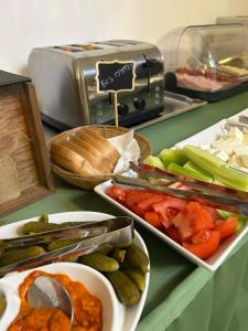 a counter top with plates of vegetables and a toaster at Hotel Mediteraneo Garni in Novi Sad +84 photos
