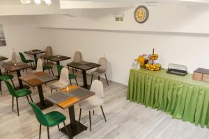 a restaurant with tables and chairs and a green counter at Hotel Mediteraneo Garni in Novi Sad
