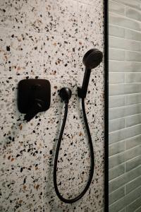 a shower with a black shower head on a wall at Cabin Balaton in Vonyarcvashegy