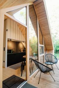 a house with a large window and two chairs at Cabin Balaton in Vonyarcvashegy