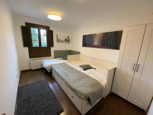 ein Schlafzimmer mit zwei Betten und einem Schrank in der Unterkunft Mendia in Jaca + 18 Fotos