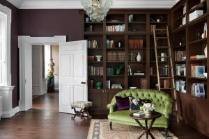 a living room with a green chair and bookshelves at Dripsey Castle Estate in Dripsey