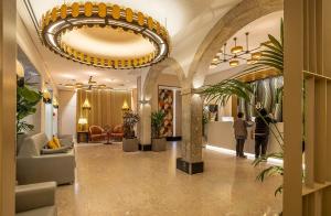 hol z dużym żyrandolem i roślinami w nim w obiekcie Hotel Santa Justa w Lizbonie