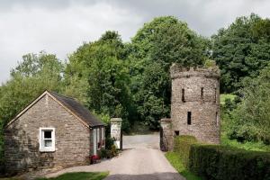 a building with a tower next to a dirt road at Dripsey Castle Estate in Dripsey