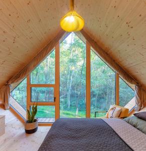 a bedroom in a house with a large window at Cabin Balaton in Vonyarcvashegy