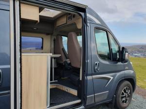 an open door of a van with a desk inside at Adventure Campervan to Explore the Faroes in Hoyvík