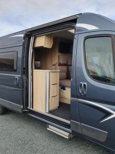 a blue van with its door open with aartments at Adventure Campervan to Explore the Faroes in Hoyvík