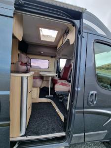 an open door of an rv with a table and chairs at Adventure Campervan to Explore the Faroes in Hoyvík
