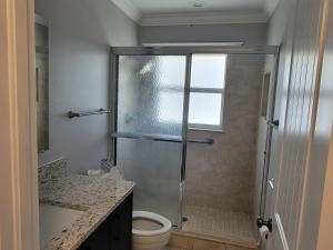 a bathroom with a shower with a toilet and a sink at Manatee River Bungalows - 2 in Bradenton +17 photos