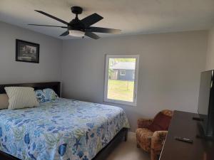 a bedroom with a bed and a ceiling fan at Manatee River Bungalows - 2 in Bradenton