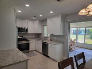 a kitchen with white cabinets and a table and chairs at Manatee River Bungalows - 2 in Bradenton