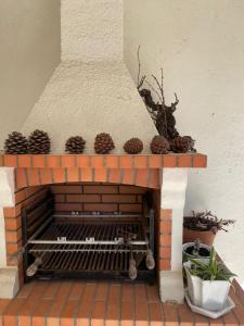 a brick fireplace with pine cones on top of it at Vino Domus in Cabeção