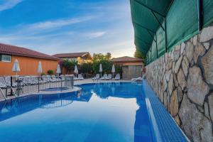 a pool at a resort with chairs and umbrellas at Ozlem Garden Hotel in Side