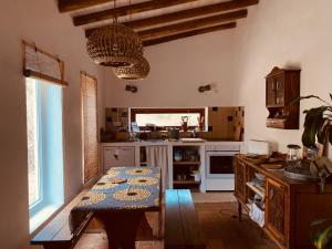 a kitchen with a table in the middle of it at Monte das Raizes in São Teotónio