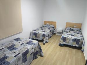 a room with three beds in a room at Casa Campo Gerena in Sanlúcar de Barrameda