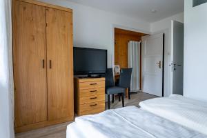 a bedroom with a bed and a desk with a television at Gästehaus Alpenkranz in Garmisch-Partenkirchen