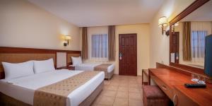 a hotel room with two beds and a television at Ozlem Garden Hotel in Side +37 photos