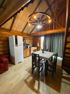 a kitchen with a table with chairs and a refrigerator at Cabana Do Lago in Joinville