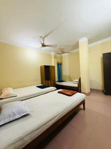 a bedroom with two beds and a ceiling at Green View Resthouse in Sreemangal