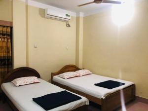 two twin beds in a room with a fan at Green View Resthouse in Sreemangal