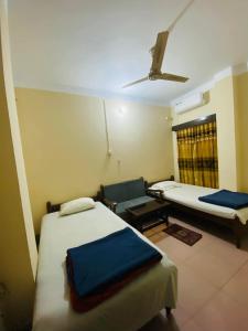 a room with two beds and a couch and a window at Green View Resthouse in Sreemangal +9 photos