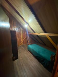 a room with a green bed in a tent at Cabana Do Lago in Joinville