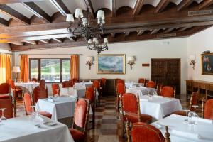 a dining room with white tables and red chairs at Parador de Fuente Dé in Fuente Dé