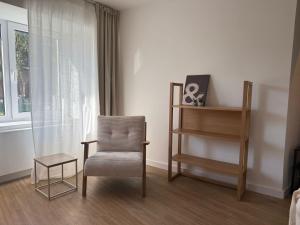 a room with a chair and a table and a window at Superior Apartment mit 1 Schlafzimmer in Hildesheim +4 photos