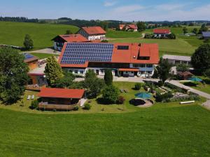 an aerial view of a house with solar panels on it at Ferienhof Rummel Allgäu - verschiedene Unterkünfte für bis zu 6 Personen - Sauna, Spielplatz, Lagerfeuer & Frühstücksservice - ideal für Familien- und Aktivurlaub in Argenbühl +95 photos